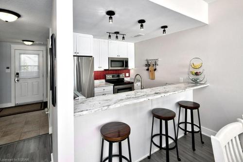a kitchen with white cabinets and bar stools at Great Location, Pool, Blue Mountain 2 BDRM Dream in Blue Mountains