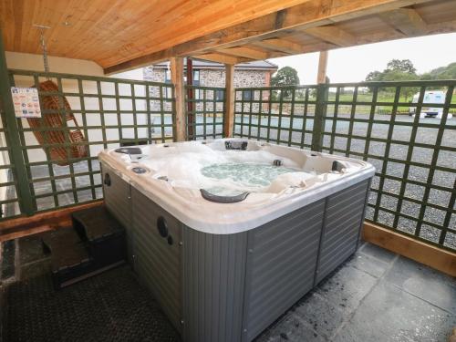 a jacuzzi tub in a building with a wooden ceiling at Y Stabl The Stable in Oswestry