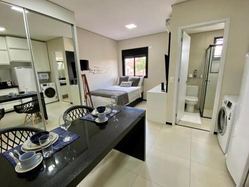 a room with a kitchen and a living room at Studio32B decorado Bairro Fragata in Marília