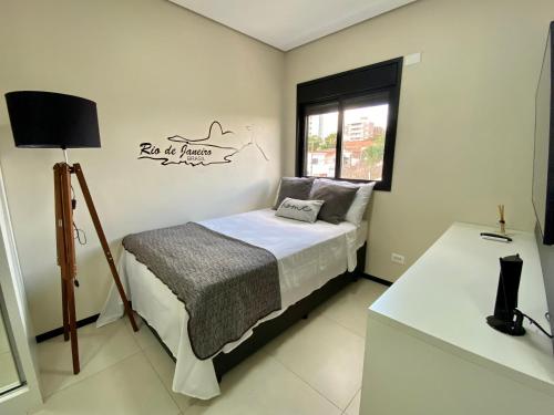 a small bedroom with a bed and a window at Studio32B decorado Bairro Fragata in Marília