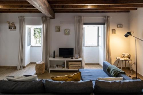 a living room with a couch and a tv at Casa da Judiaria in Castelo de Vide
