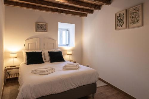 a bedroom with a bed with two towels on it at Casa da Judiaria in Castelo de Vide