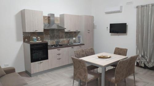a kitchen with a table with chairs and a stove at Cocciu d'amuri in Sciacca