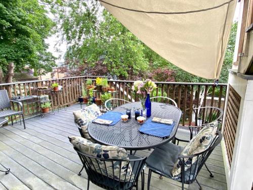 a table with chairs and a vase of flowers on a deck at Northey Street House in Salem