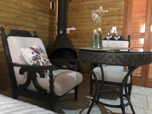 uma sala de jantar com uma mesa e cadeiras e um fogão em Chalés Itaimbezinho em Praia Grande