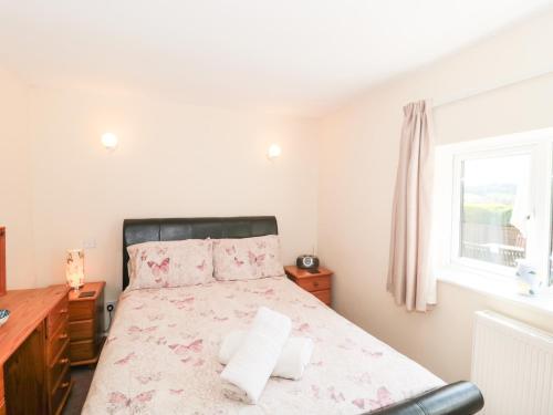 a bedroom with a bed and a window at Ryecross Farm Cottage in Melbury Abbas