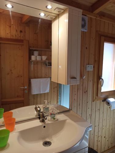 La salle de bains est pourvue d'un lavabo et d'un miroir. dans l'établissement Chalet SEAESTA COMFORT Lago di Lugano, à Porlezza