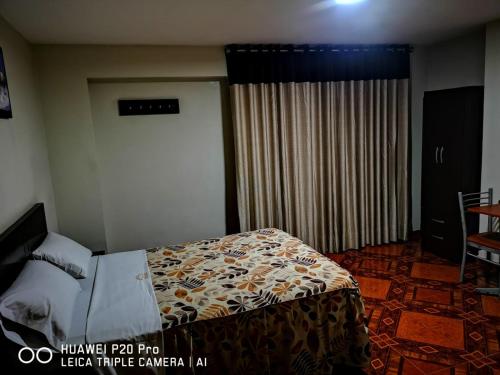 a hotel room with a bed and a window at Antares Inn in Lima