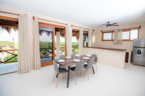 una cucina e una sala da pranzo con tavolo e sedie di Hotel Luna Roja Holbox a Isola Holbox