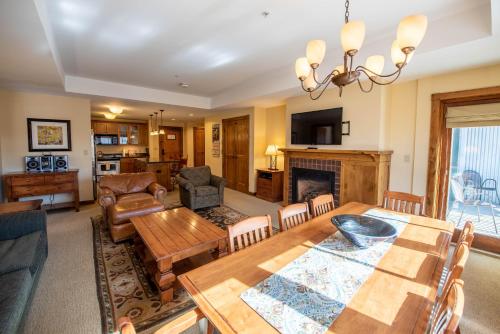 a living room with a table and a fireplace at Spacious 3 Bedroom Condo with Balcony in Mountaineer Square condo in Crested Butte