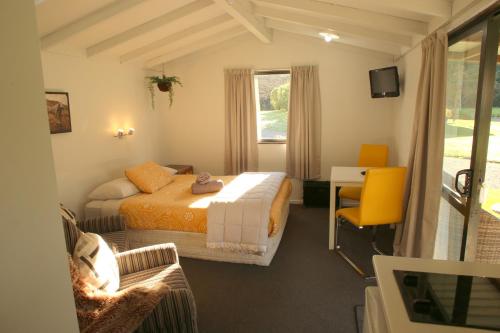 1 dormitorio con 2 camas, escritorio y silla en Parklands Marina Holiday Park, en Picton