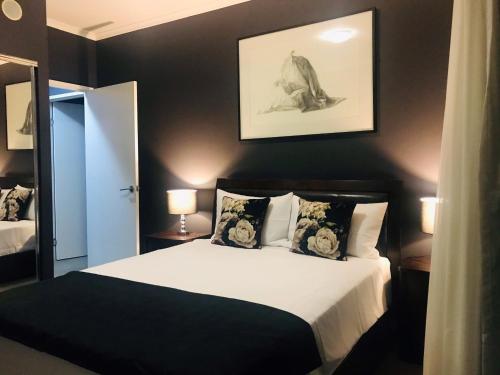 a bedroom with a bed with a black wall at The Perfect Host @ Curtis Apartments in Gladstone