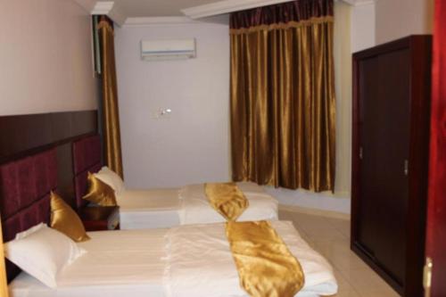 a hotel room with a bed with a tie on it at Al Samia apartment in Baljurashi