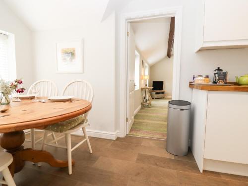 Una cocina y un comedor con una mesa de madera. en Peewit Barn, en Moreton-in-Marsh