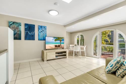 uma sala de estar com uma televisão e uma mesa em Korora Bay Village Resort em Coffs Harbour