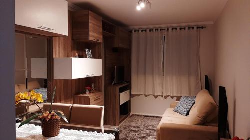 uma sala de estar com um sofá e uma televisão em Apto Cruzeiro do Sul com Wi-Fi em São José dos Pinhais
