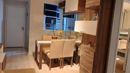 uma sala de jantar com uma mesa e cadeiras e uma janela em Apto Cruzeiro do Sul com Wi-Fi em São José dos Pinhais