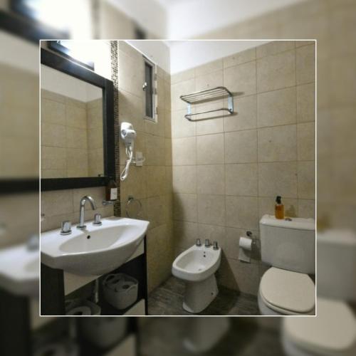 ein Badezimmer mit einem Waschbecken, einem WC und einem Spiegel in der Unterkunft Depto.shanti-guemes Mar del Plata in Mar del Plata