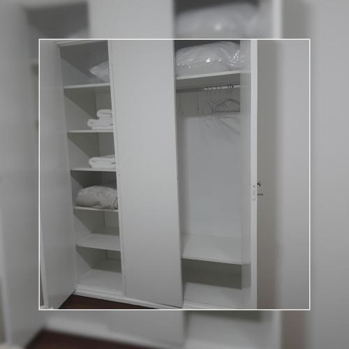 a white closet with white shelves and a door at Depto.shanti-guemes Mar del Plata in Mar del Plata