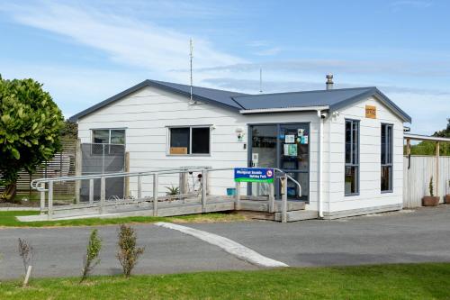 a white building with a sign in front of it at Whanganui Seaside Holiday Park in Whanganui