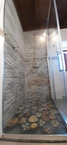 a bathroom with a shower with a stone floor at Mirador del Navia in Serandinas
