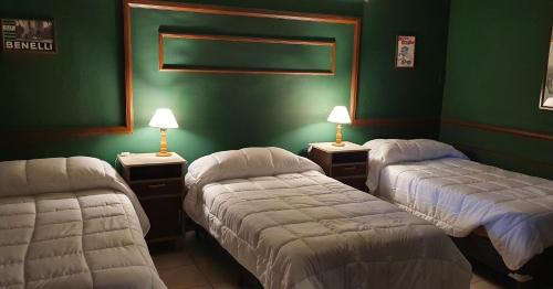 two beds in a room with green walls at Museo Posada Benelli in San Rafael