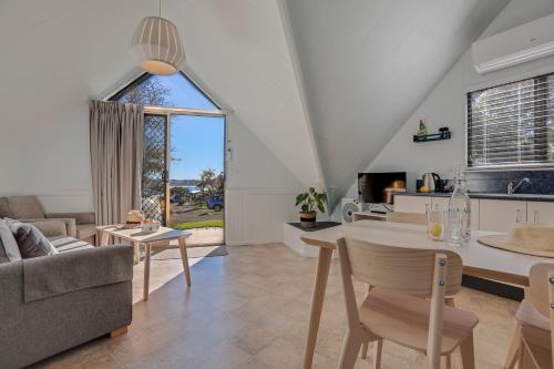 a living room with a table and a couch at Beach Cabins Merimbula in Merimbula