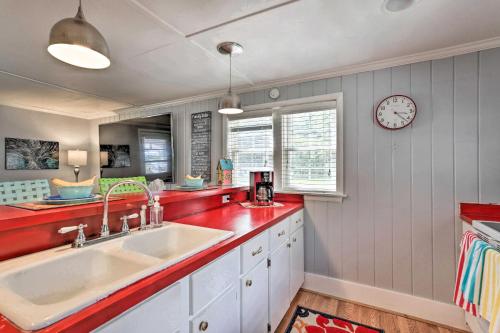 uma cozinha com um lavatório e um relógio na parede em Idyllic Waterfront Escape with Private Boat Dock! em Santee