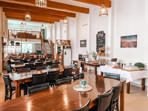 a restaurant with wooden tables and chairs and a staircase at Ajax Ski Club in Mount Buller