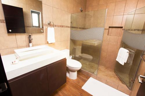 y baño con lavabo, aseo y ducha. en Hotel El Faro, en Monterrico
