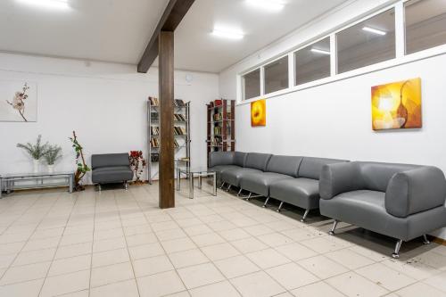 a waiting room with couches and chairs in a building at Pansionat Energetik in Nilovka