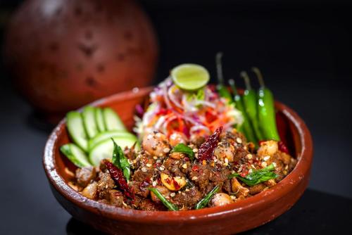 a bowl of food with vegetables and meat at Hotel Aadithya in Chennai