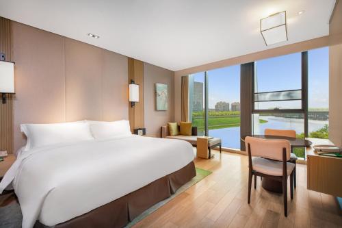 a large bed in a room with a large window at Holiday Inn Nanjing Qinhuai South Suites by IHG in Jiangning