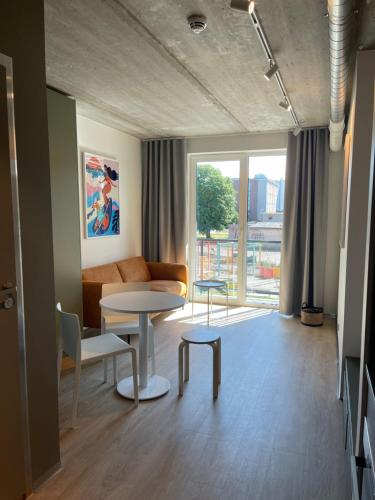 a living room with a couch and a table and chairs at Campus House by Larsen in Tallinn
