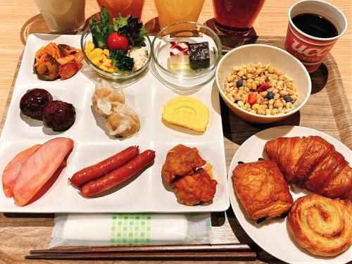 a plate of food with sausage and other foods on a table at Smile Hotel Premium Hakodate Goryokaku in Hakodate