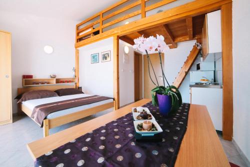 Villa Brigita في أوميس: غرفة بها سرير وطاولة عليها زهور