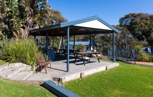 a pavilion with a picnic table in a park at Beach Cabins Merimbula in Merimbula