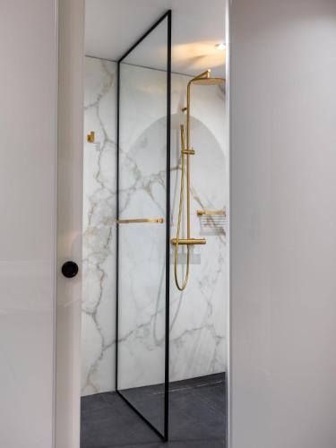 a bathroom with a shower with a glass door at Amazon Hotel in Athens
