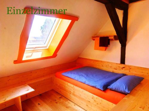 a bed in a room with a window at Der Eulenblick - Seminarhaus, Ferienhaus, Gästehaus, Reitstation, Am Waldrand in Tewswoos