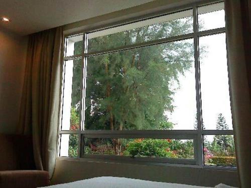 a bedroom window with a view of a tree at Straits View Hotel JB in Johor Bahru