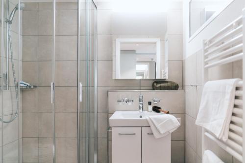 a bathroom with a sink and a shower at Hotel Müllerhof in Frick