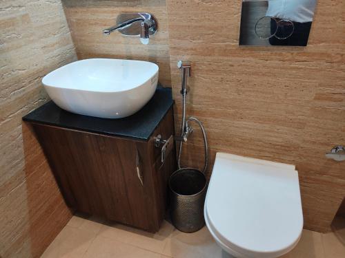 a bathroom with a white sink and a toilet at Hotel Guru Surbhi in Pāonta Sāhib