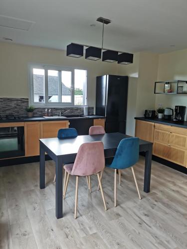 a kitchen with a black table and two chairs at Maison-Gîte "au bord de l'oust "avec jacuzzi in La Chapelle