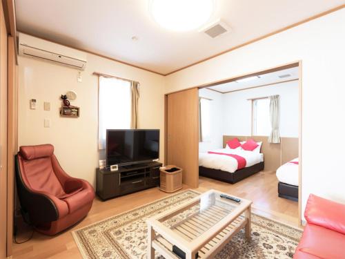 - un salon avec un lit et une télévision dans l'établissement Tama Hotel, à Ishinomaki