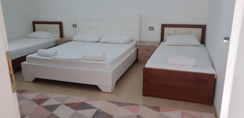 a bedroom with two beds and two night stands at Guesthouse Anila in Divjakë