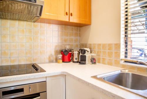 a kitchen with a sink and a counter top at Presidential Bungalow in Busselton