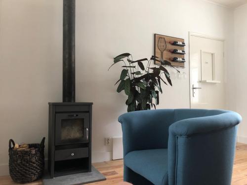 a living room with a blue chair and a fireplace at B&B - Make a Wisch in Silvolde