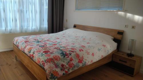 um quarto com uma cama com um edredão floral em B&B - Make a Wisch em Silvolde