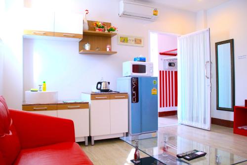 een keuken met een blauwe koelkast en een magnetron bij The Cottage Lampang in Lampang