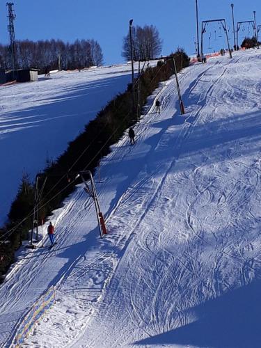 a group of people skiing down a snow covered slope at 3 Sterne Ferienwohnungen Wachter in Bischofsgrün